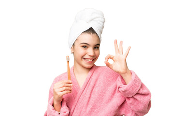 Wall Mural - Little girl brushing teeth over isolated chroma key background showing ok sign with fingers