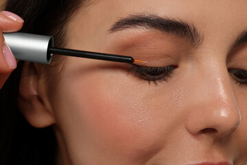 Canvas Print - Woman applying serum onto her eyelashes, closeup. Cosmetic product