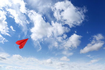 Poster - Red paper plane flying in blue sky with clouds