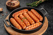 Raw bavarian sausages with spice and herbs in pan. Food recipe background. Close up