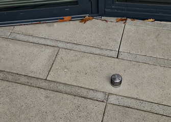 stainless steel door stop. concrete tile with rubber post in the shape of a cylinder. stops opening to full extent. this will prevent damage to the handle or the door lining or the hinge