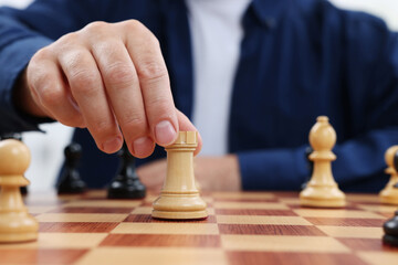 Poster - Man with rook game piece playing chess at checkerboard, closeup