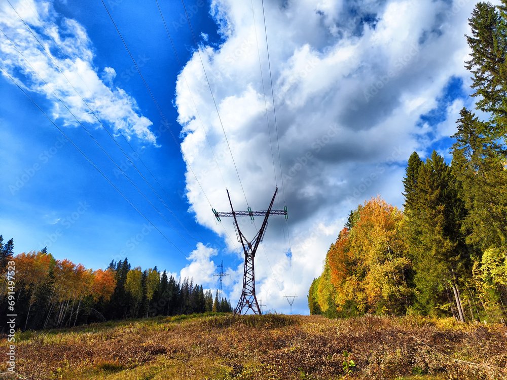 Power lines on a hill, hill or in the mountains against a blue sky with ...