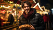 Young man eating hot dog while standing at Christmas market