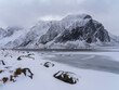 Snowcapped Lofoten mountains with ice water surface