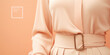 Minimal concept fashion clothing in peach fuzz color, trend of 2024 year. Close-up of a detail of stylish skirt.