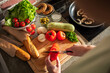 © Marko Geber - Fresh vegetables on kitchen countertop with woman cooking at home