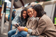 © Davor - Beautiful young women using smartphone at train station