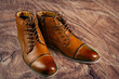 A pair of premium calfskin boots on a wooden background. Horizontal shot.
