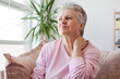 Unhappy 60 years old woman have pain neck at home