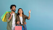 © Prostock-studio - Happy young eastern couple shopaholics pointing at copy space
