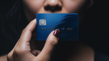 Close-up Of Woman Holding Bank Credit Or Debit Card In Front Of Her Lips, Extorsion Concept, Keeping Mouth Shut,
