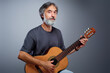 © luengo_ua - Aged bearded man with an acoustic guitar