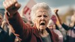 An empowering image of an elderly woman showing strength and determination by raising her fist. Perfect for inspiring messages or advocating for causes related to empowerment and activism