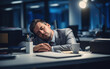A tired businessman is sleeping at his desk