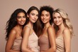 Half-length studio portrait of four cheerful young diverse multiethnic women. Female models smiling at camera while posing together. Diversity, beauty, friendship concept. Beige monochrome background.