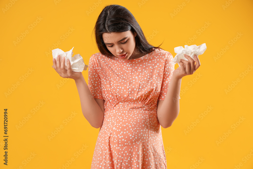 Sick pregnant woman on yellow background