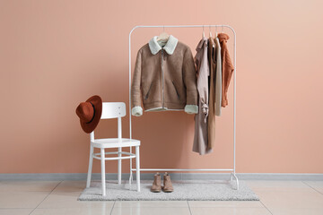 Wall Mural - Rack with stylish female clothes, accessories and shoes near color wall