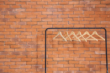 Wall Mural - Rack with wooden hangers near brick wall