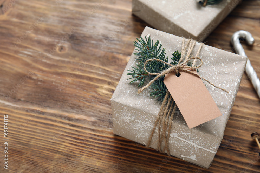 Beautiful Christmas gift with blank tag on wooden background