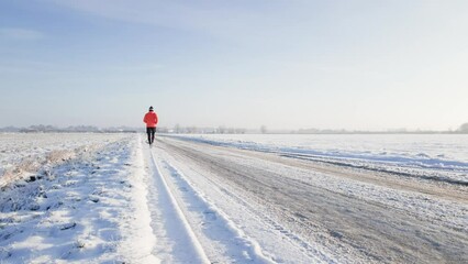 Wall Mural - Male runner jogging on winter snowy road, preparing for competition. Winter running exercises. Athlete training at cold frozen day