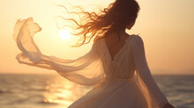 Beautiful Girl In A White Dress Dancing On The Beach At Sunset