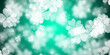 Abstract light green background with flying four leaf clovers