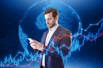 Poster - Portrait of attractive young european businessman using cellphone with globe and candlestick forex chart. Metaverse, finance and trade concept.