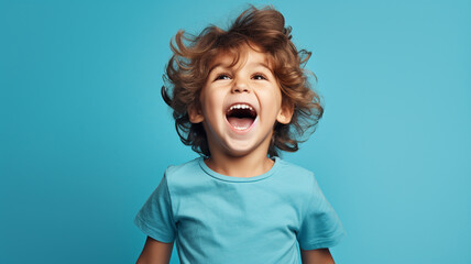 Very happy little child standing on blue background