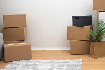 Aufkleber - Numerous cardboard boxes of different sizes for things stand on floor with carpet near wall prepared by young family for moving to new apartment in another city