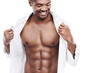 Man, fashion and muscle with abs, shirt and dressing for chest, african and male model in white background. Alone, smile and happy with six pack, body and corporate wear, stylish and masculine