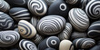 Monochromatic grey pebble with swirl pattern. Some stones are light grey tones and some are dark, background with copy space