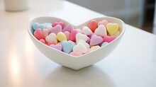 A Serene White Porcelain Heart-shaped Dish Filled With Colorful Candies Against A Clean White Setting.