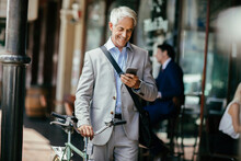 Smiling Businessman Using Smartphone During Work Commute