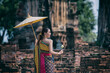 woman with umbrella. women in traditional clothing  on Buddhist on background.  Portrait women in traditional clothing , Thai traditional  in Ayutthaya, Thailand.