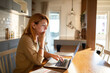 Focused young woman working from home on laptop