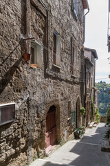 Wall Mural - old houses on narrow downhill lane at medieval hilltop village, Pitigliano, Italy