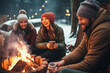 Happy friends having fun and relaxing around fire pit. Winter party outside