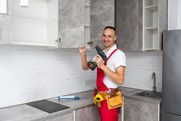 Young repairman working at the kitchen