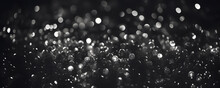Abstract Silver Defocused Glitter Lights Bokeh On Black Background. Festive Holiday Design Template 