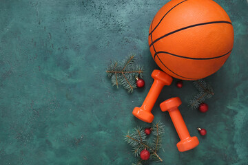 Wall Mural - Composition with basketball ball, dumbbells and Christmas tree branches on green background