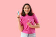 © Pixel-Shot - Young woman with electronic cigars on pink background