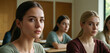 sad young teenager or caucasian young adult woman, student at university or high school, in a classroom with other women. fictional location
