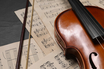 Sticker - Violin, bow and music sheets on black table, closeup