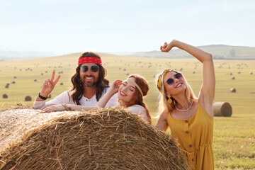 Canvas Print - Happy hippie friends near hay bale in field