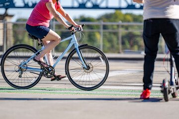 Wall Mural - An elderly woman prefers cycling and outdoor exercise to maintain health and the whole body in good shape rather than riding an electric scooter