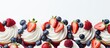 Close-up photo of cupcakes with strawberries and blueberries on a plate.