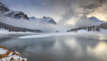 Winter Mist Blanketing The Frozen Champfer Lake, Engadine, Canton Of Graubunden, Switzerland
