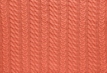 Wall Mural - Texture of smooth knitted sweater with pattern. Handmade knitting wool or cotton fabric texture. Background of Large knit pattern with knitting needles or crochet. Peach Fuzz colour of 2024 year