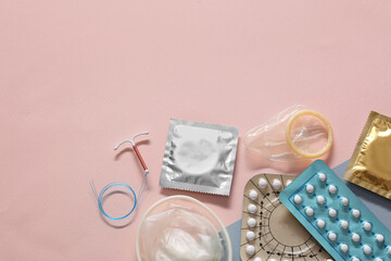 Wall Mural - Contraceptive pills, condoms and intrauterine device on beige background, flat lay with space for text. Different birth control methods